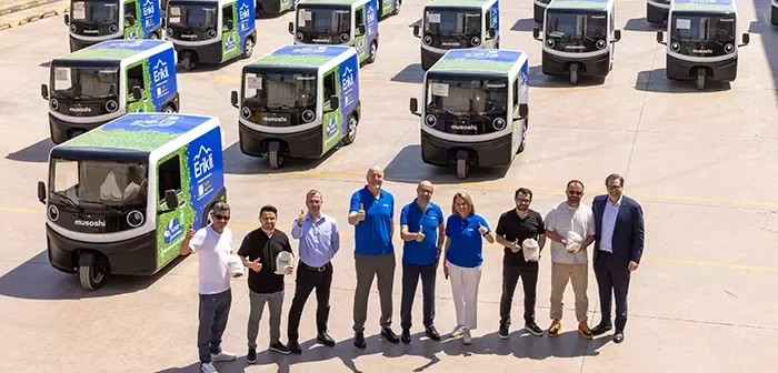 Nestle çalışanları ve arkalarında ki elektrikli arabalar